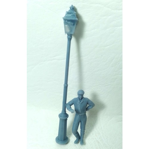 Farola con hombre apoyado con el codo.